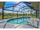 A lovely kidney-shaped pool surrounded by a screened enclosure allows for views of the manicured backyard at 269 Mark Twain Ln, Rotonda West, FL 33947