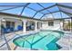 Inviting screened-in pool area with stone tile deck, poolside seating, and covered lanai at 269 Mark Twain Ln, Rotonda West, FL 33947