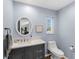 Charming bathroom with a sleek vanity, round mirror, and calming blue walls at 27215 Crosby Rd, Myakka City, FL 34251