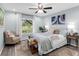 Bright bedroom featuring a neutral color scheme, ceiling fan, and a large window at 27215 Crosby Rd, Myakka City, FL 34251