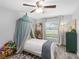 Cozy bedroom features a stylish canopy bed, soft rug, and natural light at 27215 Crosby Rd, Myakka City, FL 34251