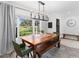 Bright dining room features a large bay window, wood table with seating, and stylish chandelier at 27215 Crosby Rd, Myakka City, FL 34251