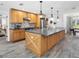 Well-lit kitchen with a large island, stainless steel appliances and wood cabinets and adjacent dining area at 27215 Crosby Rd, Myakka City, FL 34251