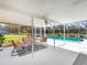 Enclosed patio features seating and a view of the sparkling swimming pool at 27215 Crosby Rd, Myakka City, FL 34251