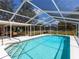 Enclosed swimming pool with seating area and white decking overlooking the serene backyard at 27215 Crosby Rd, Myakka City, FL 34251