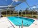 Screened pool with sparkling blue water and serene landscaping, perfect for relaxing and enjoying the outdoors at 27215 Crosby Rd, Myakka City, FL 34251