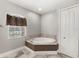 Bright bathroom featuring a soaking tub under a window and a linen closet at 2769 Dode Ave, North Port, FL 34288