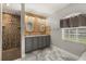 Bright bathroom with double vanity, wood accent wall, decorative mirrors, and tiled walk-in shower at 2769 Dode Ave, North Port, FL 34288