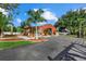 View of the red barn-style building, showing paved driveway and manicured landscaping at 2769 Dode Ave, North Port, FL 34288