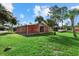 Exterior of the red building with manicured green lawn and palm tree landscaping at 2769 Dode Ave, North Port, FL 34288