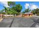 Wide paved driveway leading to a red building surrounded by lush landscaping and palm trees at 2769 Dode Ave, North Port, FL 34288