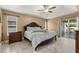 Bright main bedroom featuring a tray ceiling, light floors, and a sliding glass door to the lanai at 2769 Dode Ave, North Port, FL 34288