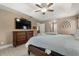 Open main bedroom featuring wood floors, a tray ceiling, dresser, and a large tv at 2769 Dode Ave, North Port, FL 34288