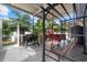 Expansive screened outdoor kitchen area with built-in barbecue, comfortable swing, and lush landscaping at 2769 Dode Ave, North Port, FL 34288