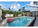 Spacious screened-in pool surrounded by lush landscaping and blue skies at 2769 Dode Ave, North Port, FL 34288
