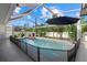 Screened-in pool and lanai area surrounded by lush landscaping and blue skies at 2769 Dode Ave, North Port, FL 34288