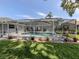 Backyard pool and screened-in lanai surrounded by green grass at 304 Rosewood Ct, Venice, FL 34293