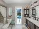 Bathroom boasts detailed vanity, white tile and seamless access to pool area at 304 Rosewood Ct, Venice, FL 34293