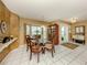 Well-lit dining room featuring tile floors, a modern chandelier and a glass-top table at 304 Rosewood Ct, Venice, FL 34293
