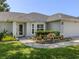 Close-up of the home's front yard featuring flowerbed landscaping and the front door at 304 Rosewood Ct, Venice, FL 34293