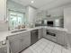 Bright kitchen features stainless appliances, white countertops, and gray cabinets at 304 Rosewood Ct, Venice, FL 34293