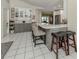 Kitchen with tile flooring, gray lower cabinets, white upper cabinets, and barstool seating at 304 Rosewood Ct, Venice, FL 34293