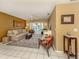 Comfortable living room featuring a cream sofa, piano and a view to the backyard at 304 Rosewood Ct, Venice, FL 34293