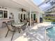 Screened patio with dining and living spaces next to swimming pool at 304 Rosewood Ct, Venice, FL 34293