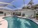 Backyard kidney-shaped pool and screened in lanai featuring an outdoor kitchen at 304 Rosewood Ct, Venice, FL 34293