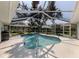 Screened in backyard pool with sunning chair and a large tree at 304 Rosewood Ct, Venice, FL 34293