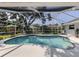 Screened in backyard pool with large trees and a sunning chair at 304 Rosewood Ct, Venice, FL 34293