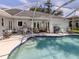 The lanai features an outdoor kitchen, several seating areas, and a pool at 304 Rosewood Ct, Venice, FL 34293