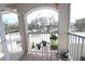 Balcony view with potted plants, metal railing, and lush green trees at 320 Clearbrook Cir # 203, Venice, FL 34292
