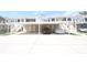 Condominium exterior showcasing covered parking, stairs leading to the 2nd floor, and a well-maintained facade at 320 Clearbrook Cir # 203, Venice, FL 34292