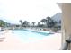 Inviting pool with lounge chairs surrounded by palm trees and lush landscaping at 320 Clearbrook Cir # 203, Venice, FL 34292