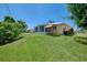 Spacious backyard with lush grass and a partially enclosed lanai attached to the home at 331 Bucknell Rd, Venice, FL 34293