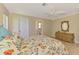 Bedroom with floral bedding, a ceiling fan, light hardwood flooring, and a bathroom entrance at 331 Bucknell Rd, Venice, FL 34293