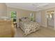 Cozy bedroom with light wood floors, windows, and floral bedding; bathroom entrance on the side at 331 Bucknell Rd, Venice, FL 34293