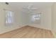 Bright bedroom with wood-look flooring, a ceiling fan, and windows with decorative curtains at 331 Bucknell Rd, Venice, FL 34293