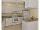 Well-lit kitchen featuring white cabinetry, granite countertops, tile floors and modern appliances at 331 Bucknell Rd, Venice, FL 34293