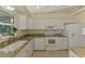Bright kitchen with white cabinets, granite countertops, modern appliances and a window overlooking a garden at 331 Bucknell Rd, Venice, FL 34293