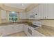 Well-lit kitchen with white cabinets, stainless steel appliances, granite countertops, and a view of the backyard at 331 Bucknell Rd, Venice, FL 34293