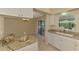 Bright kitchen boasts granite counters, white cabinetry and a window overlooking the outside at 331 Bucknell Rd, Venice, FL 34293