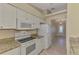 Charming kitchen with granite countertops, white appliances, and a view into the entryway at 331 Bucknell Rd, Venice, FL 34293