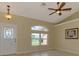 Spacious living room with tile flooring, a ceiling fan, and a decorative glass front door at 331 Bucknell Rd, Venice, FL 34293
