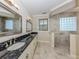 Bathroom featuring dual sinks, granite countertop, and a large walk-in shower with stone surround at 333 Sunrise Dr, Nokomis, FL 34275