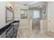 Bathroom featuring dual sinks, granite countertop, and a large walk-in shower with glass block window at 333 Sunrise Dr, Nokomis, FL 34275