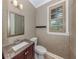 Elegant powder room with wood-framed mirror and window and a stylish granite-topped vanity at 333 Sunrise Dr, Nokomis, FL 34275