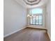 Dining area with large window, plantation shutters, chandelier, hardwood floors, and tray ceiling at 333 Sunrise Dr, Nokomis, FL 34275