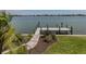 Waterfront property featuring a private dock, lush landscaping, and inviting walkway at 333 Sunrise Dr, Nokomis, FL 34275
